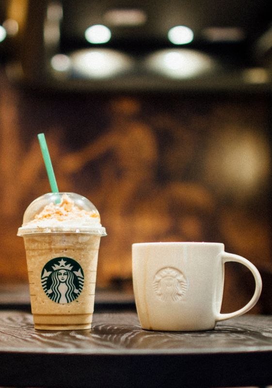Side view of a frappuccino and a coffee in a mug.