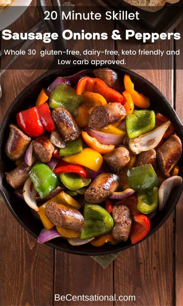 Cast iron skillet with sausage onions and peppers on a wooden table.