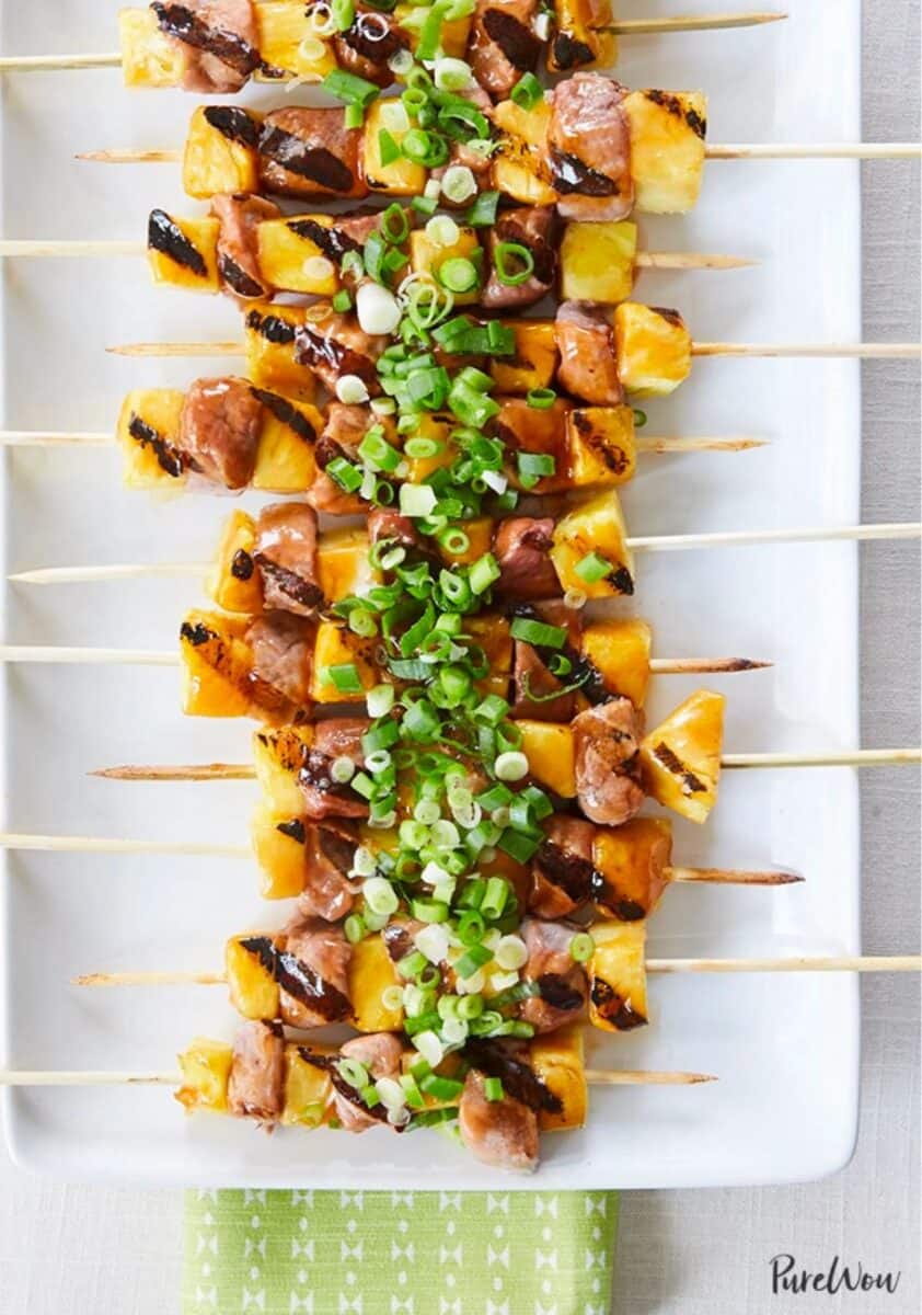 Sweet-and-Sour Pork Skewers with Pineapple on a white platter.