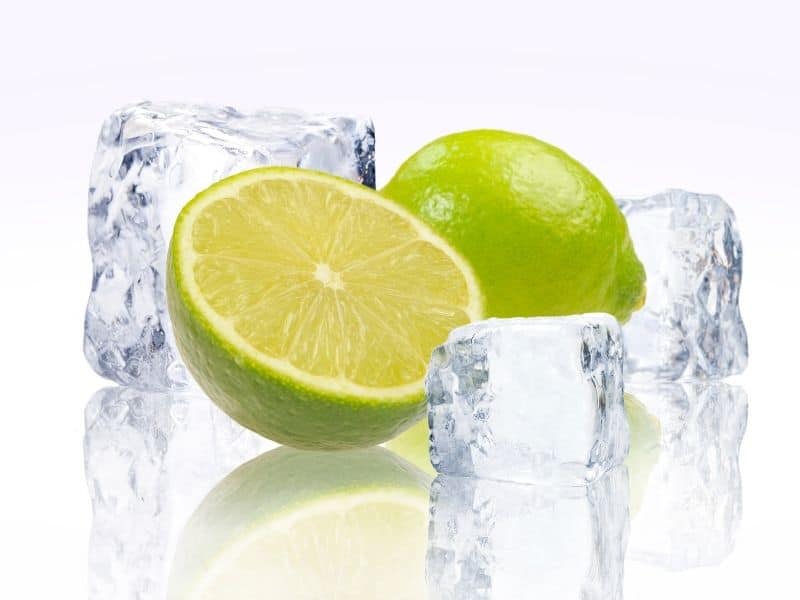 Lime split in have surrounded by ice cubes.Can You Freeze Limes?