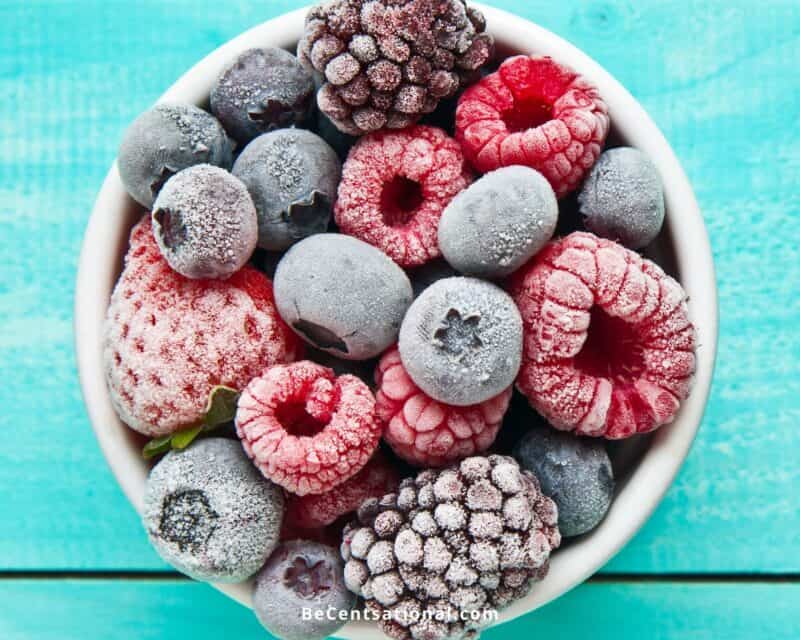 Frozen fruits in a white bowl on a blue background. Can You Refreeze Frozen Fruit?