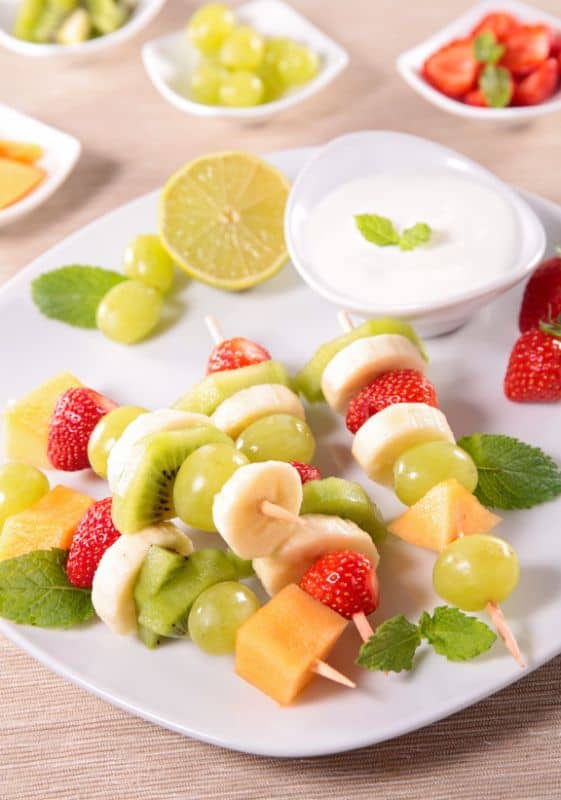 cheesecake batter dip with fruits skewers.