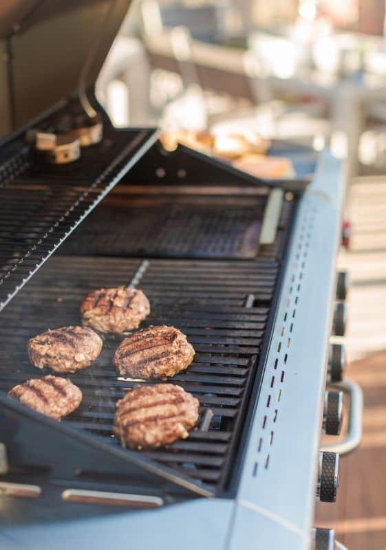 Grilling classic beef burgers on an outdoor gas grill.