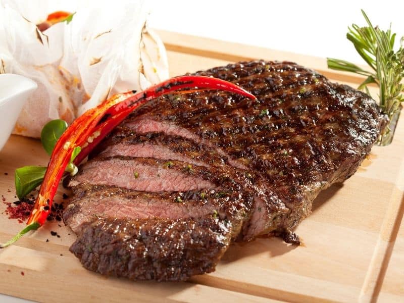 Grilled flank steak on a cutting board.