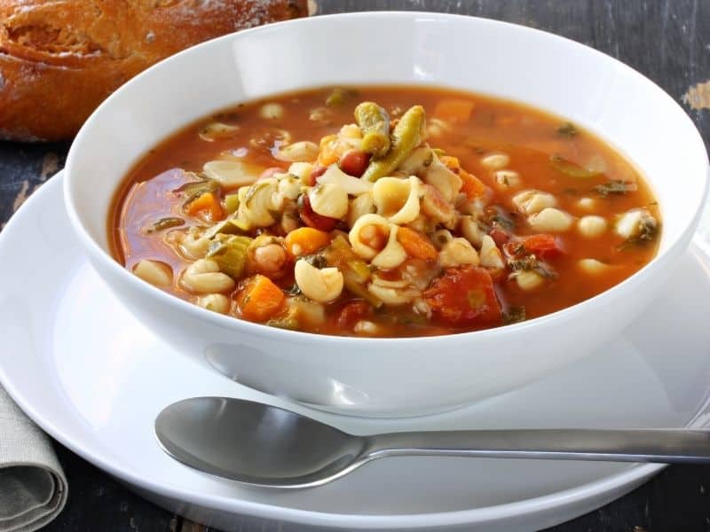 A white bowl of minestrone soup with pasta. How to Keep Pasta From Getting Mushy in Soup?