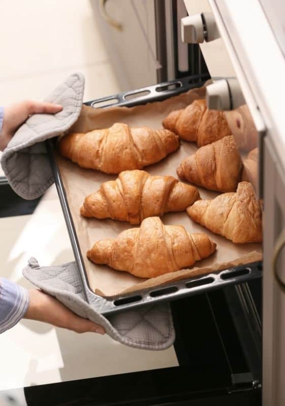 croissants being taken out of the oven after reheating them from frozen.