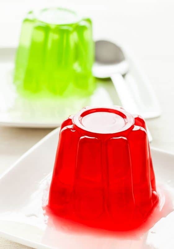 Side view of green jello and red jello on a white background.