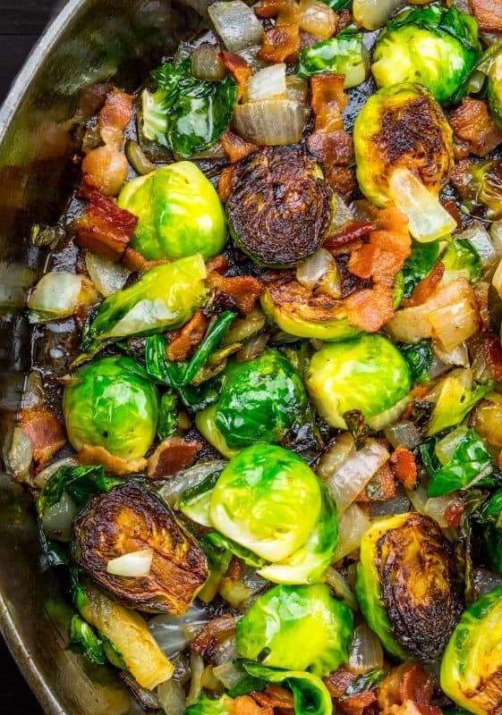 Closeup view of sautéed Brussels sprouts on a cast iron skillet.