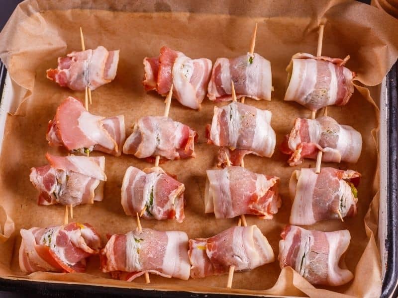 Bacon wrapped brussels sprouts in baking sheet.