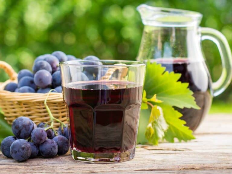 Side view of a pitcher and glass of grape juice with a basket full of grapes by the side all on a wooden table. Side view of a glass full of grape juice and grapes on the vine on the side. Does Frozen Grape Juice Concentrate Expire?