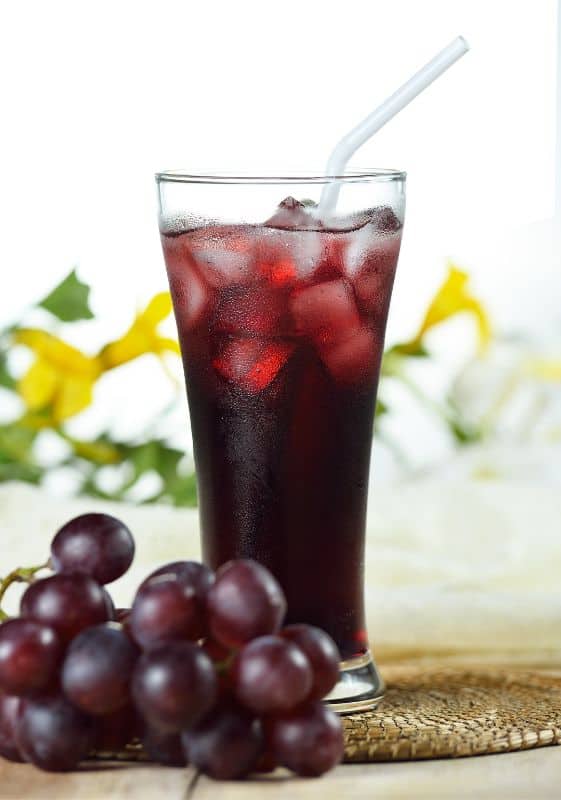 Side view of a glass full of grape juice and grapes on the vine on the side. Does Frozen Grape Juice Concentrate Expire?
