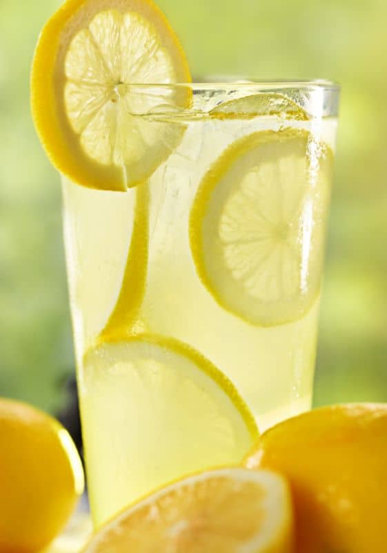 Closeup side view of a tall glass of lemonade with lemon slices. Does Frozen Lemonade Concentrate Expire.