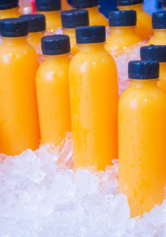 Bottles of orange juice in ice. Does frozen orange juice goes bad if kept in the refrigerator?