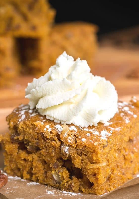 A slice of Pumpkin Pie Dump Cake topped with whipped cream.