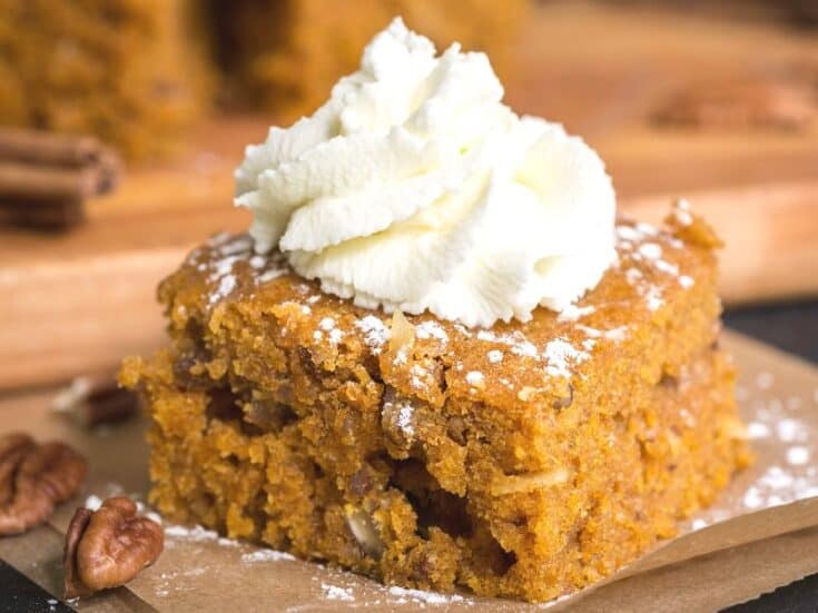 A slice of Pumpkin Pie Dump Cake topped with whipped cream.