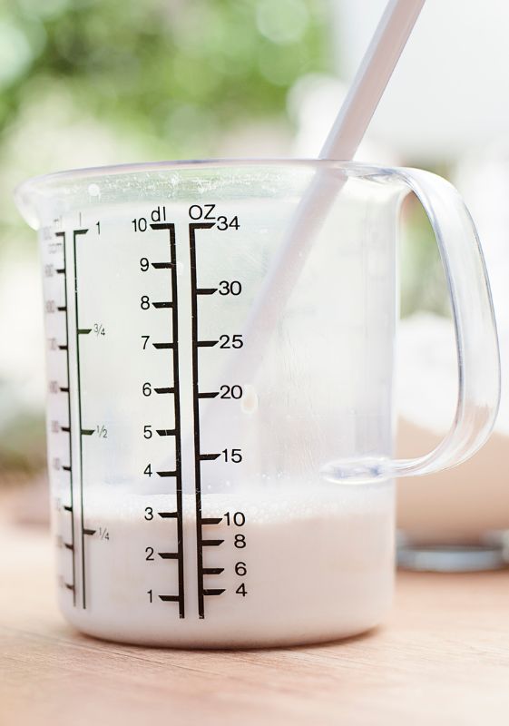 Milk in a glass measuring cup with units ounces and deciiliters.