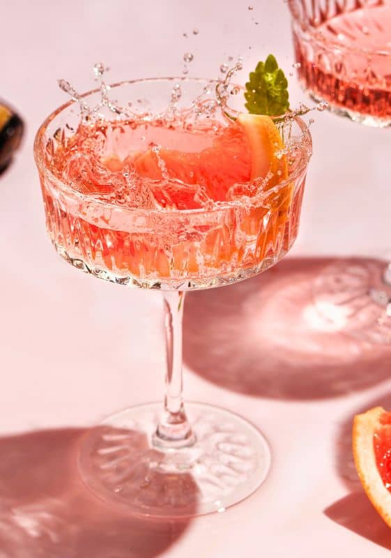 A Vodka Cocktail with grapefruit and strawberries making a splash.