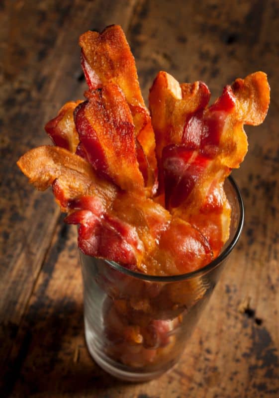 Cooked bacon served on a glass.