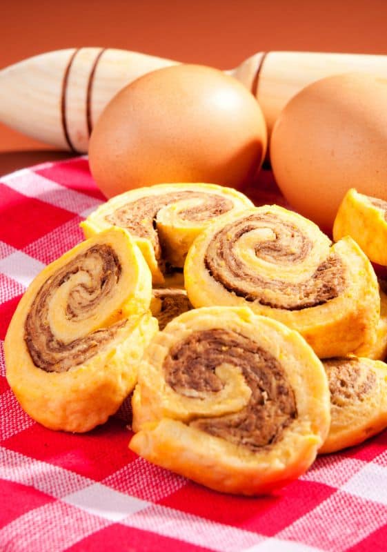 A photo of sausage pinwheels. The pinwheels are made with crescent rolls, sausage, cream cheese, and green onions. They are golden brown and look delicious.