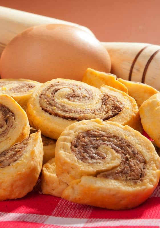 Image of a sausage pinwheel: A crescent roll filled with sausage, cream cheese, and green onions, rolled up and sliced.