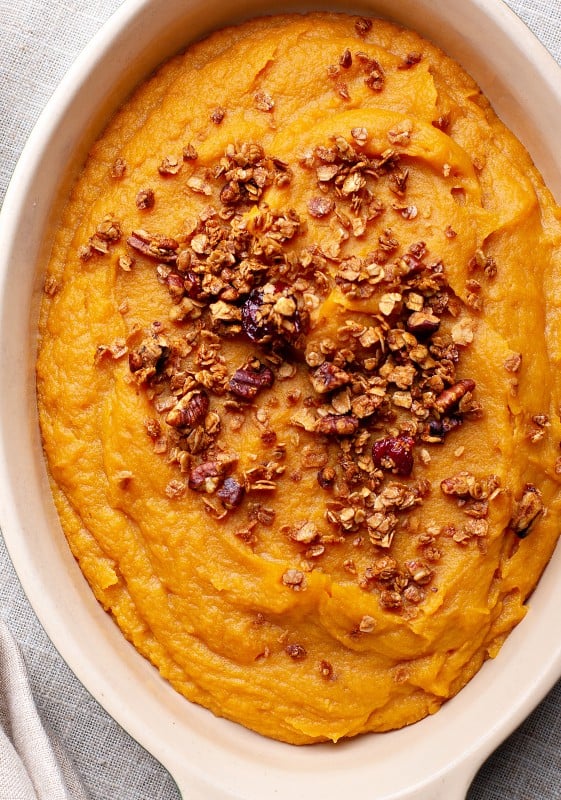 A close-up image of sweet potato casserole showing the detailed texture of the caramelized topping.