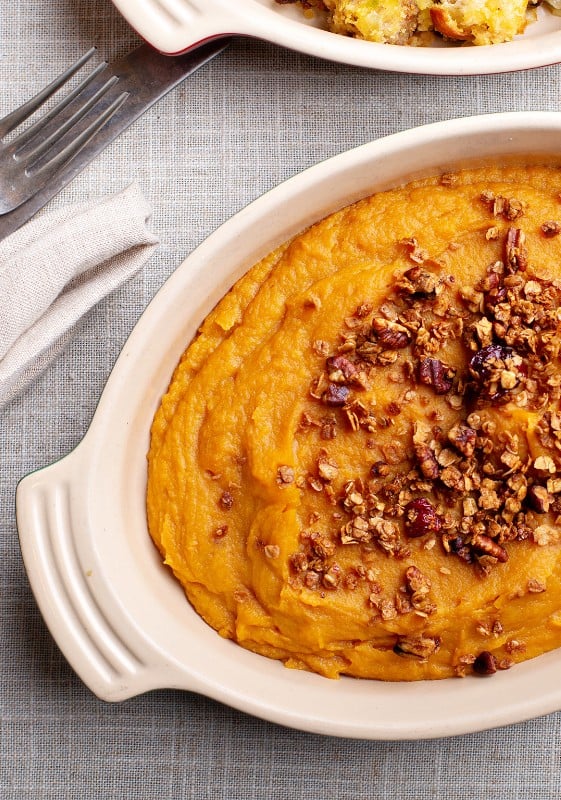 A close-up image of sweet potato casserole showing the detailed texture of the caramelized topping.