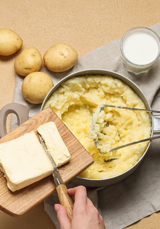 adding butter, cream to mashed potatoes.