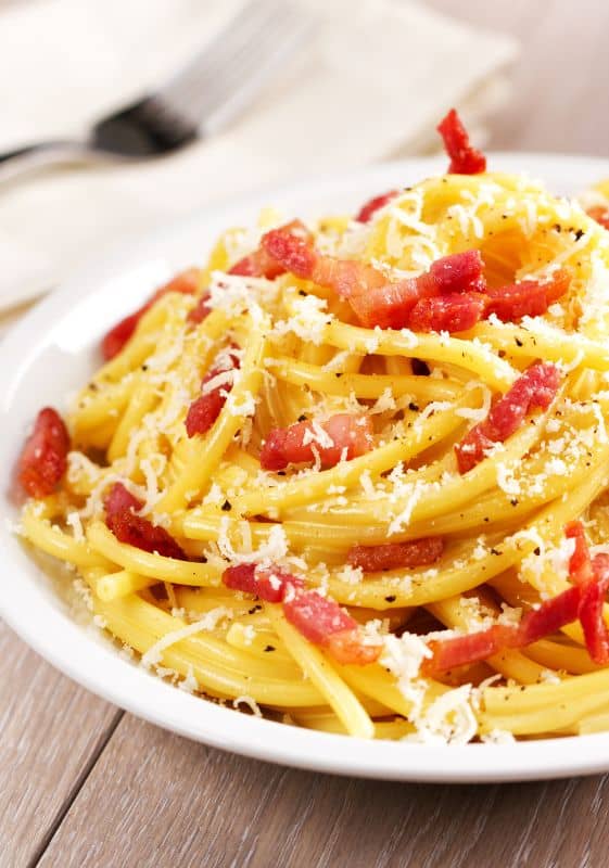 A delightful and creamy pasta dish topped with crispy bacon lardons and a touch of black pepper.