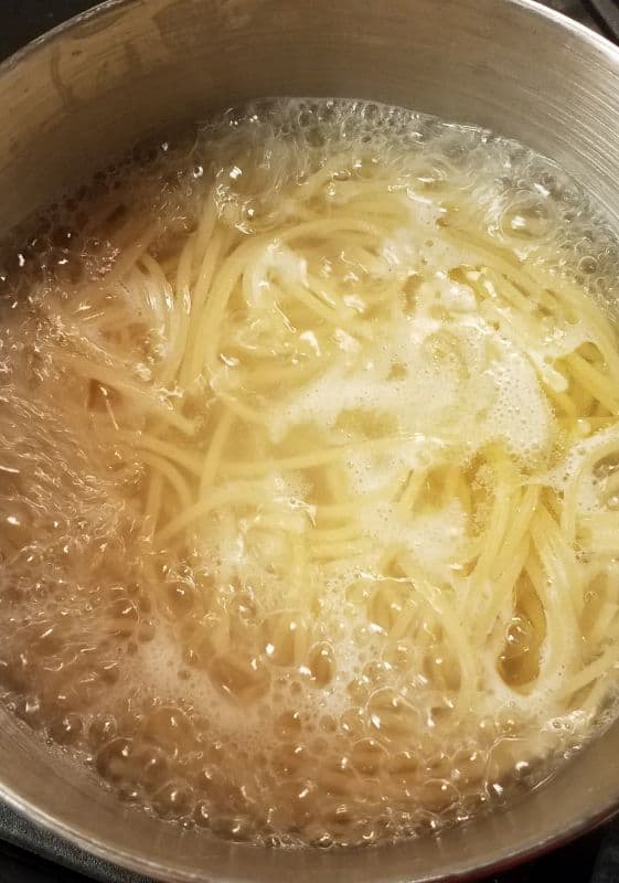 Boiling spaghetti to Al Dente: Spaghetti pasta cooking in a pot of boiling water until perfectly al dente.