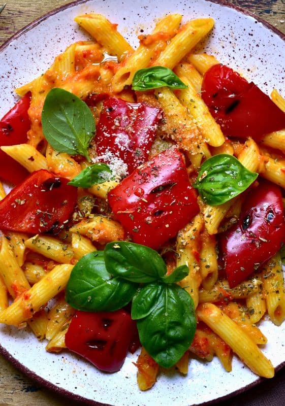 Delicious Vegetarian Rasta Pasta - A close-up view of the delectable penne pasta mingled with a rich and creamy tomato-based sauce, accompanied by a medley of grilled red bell peppers, offering a visual feast of colors and textures.