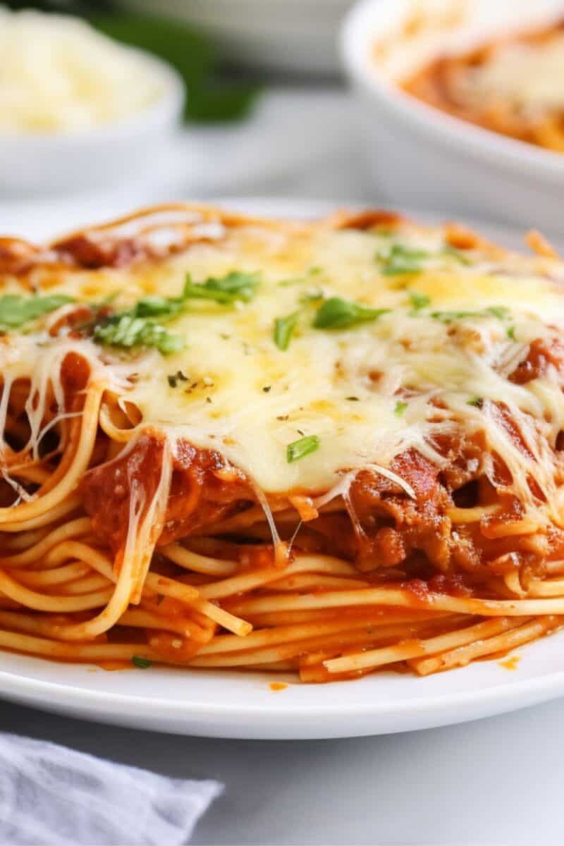 Closeup view of baked spaghetti dish garnished with fresh basil.