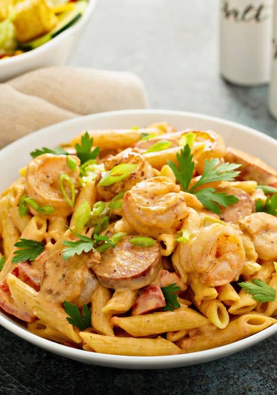 A mouth-watering bowl of creamy Cajun shrimp and sausage pasta, sprinkled with fresh parsley and parmesan. The pasta is drenched in homemade Cajun sauce, and loaded with juicy shrimp and flavorful andouille sausage, capturing the essence of Southern comfort food in one dish.
