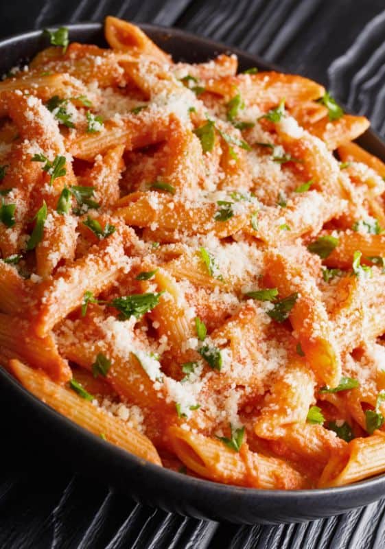 Creamy and comforting Penne alla Vodka, garnished with fresh basil and parmesan.