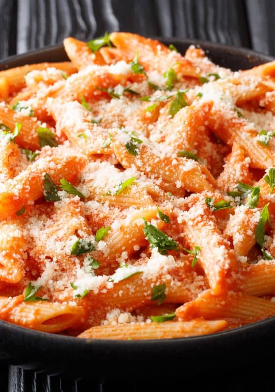 Close-up of creamy vodka sauce coating penne pasta.