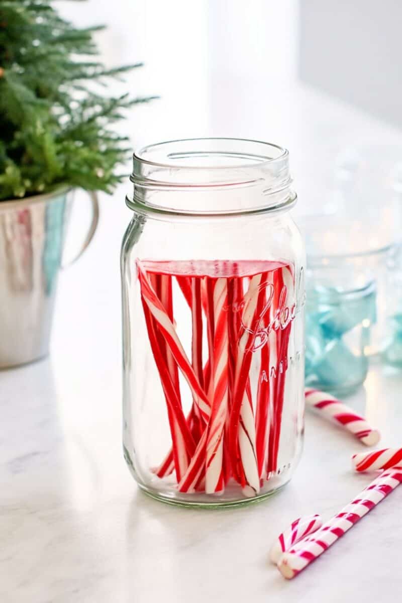 a glass jar filled with candy cane infused vodka.