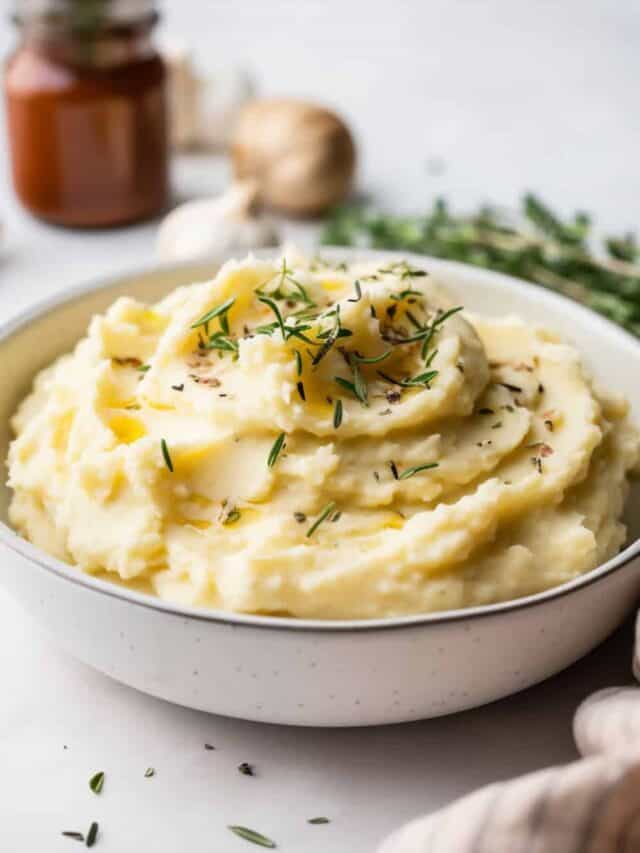 Bowl of roasted garlic mashed potatoes with a drizzle of garlic-infused oil, emphasizing the rich garlic flavor.
