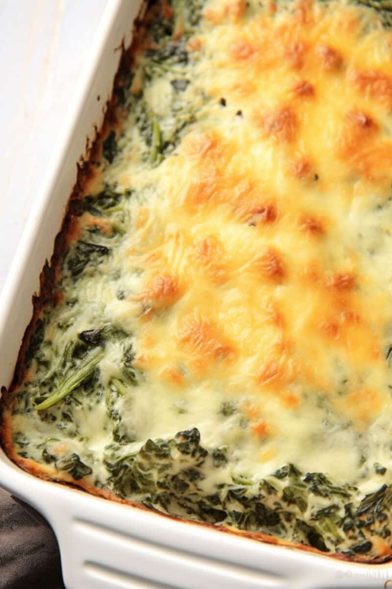 A golden-brown Spinach Gratin fresh out of the oven, showcasing a crispy cheese topping and creamy spinach filling in a ceramic baking dish.