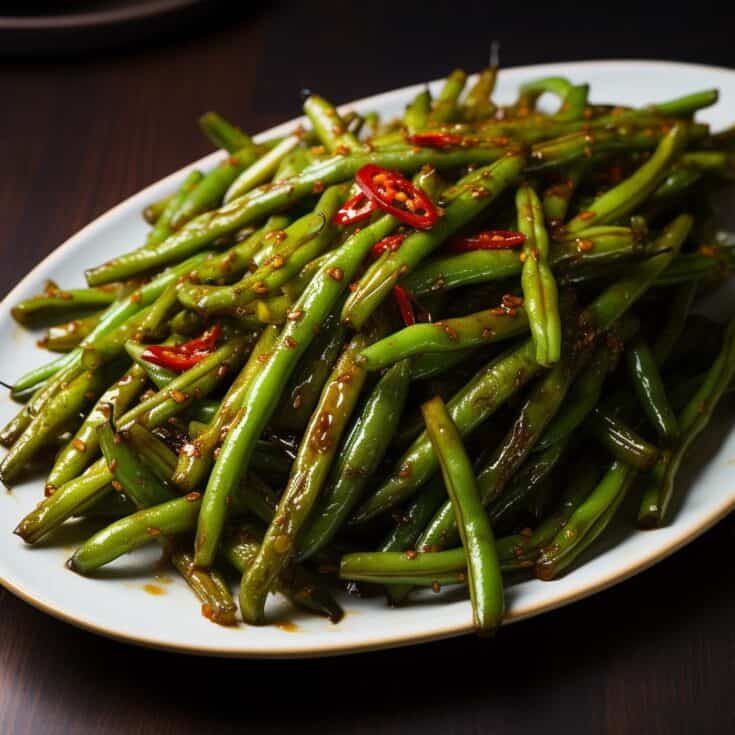Close-up of Stir-Fried Green Beans showing their bright green color and charred edges, seasoned with Asian spices, in a sleek, modern serving dish.