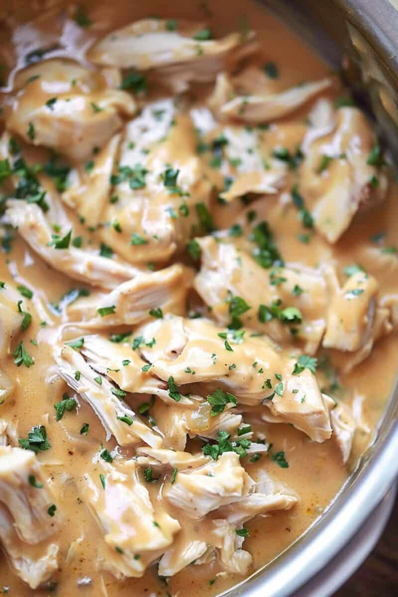 Tender chicken and rich, creamy gravy inside a crockpot, ready to be served.