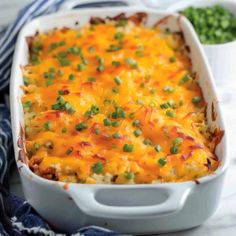 cheesy hash brown casserole in baking dish on white countertop.