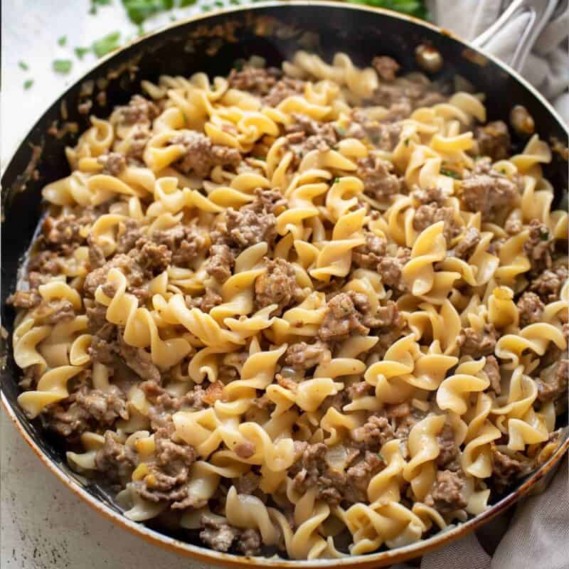 Overhead photo of Ground beef stroganoff on skillet in white countertop.