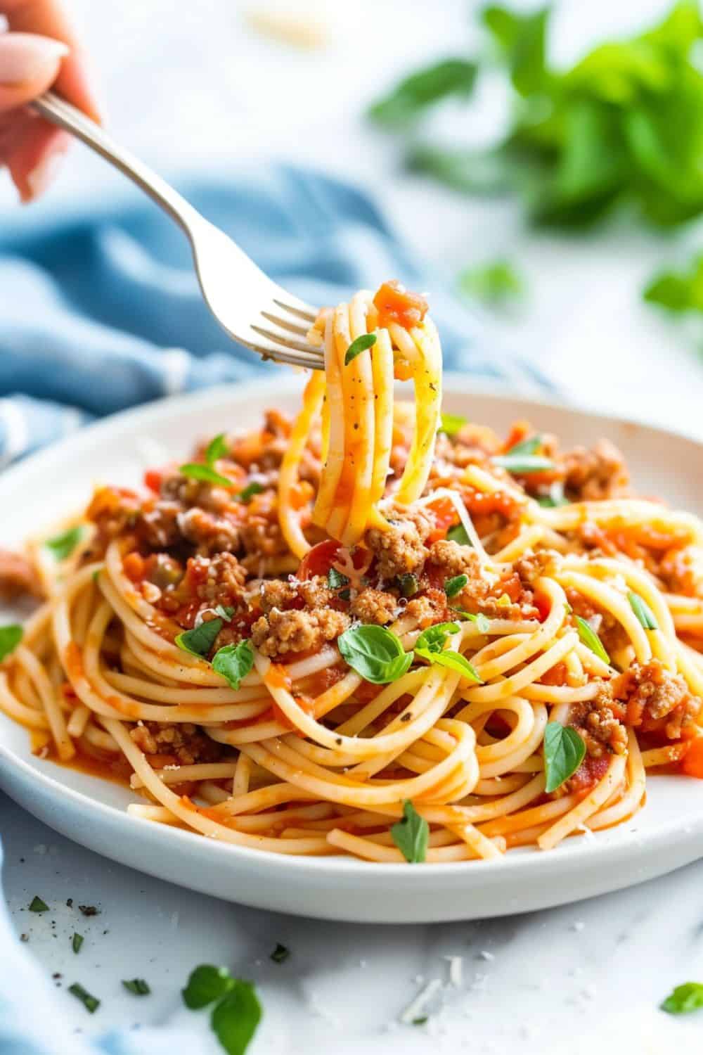 A fork twirling a generous serving of Easy Minced Turkey Spaghetti, highlighting the succulent, finely minced turkey and perfectly cooked spaghetti in a flavorful sauce.