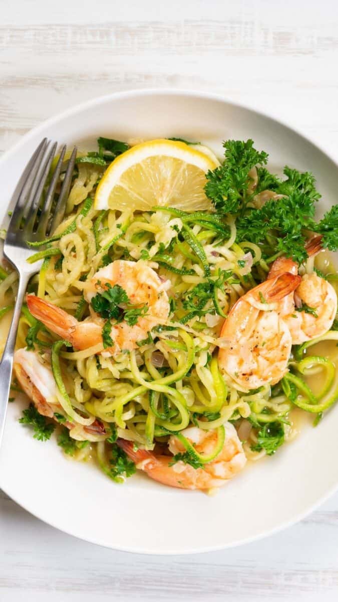 A plate of Shrimp Scampi over zucchini noodles, garnished with Parmesan and lemon, offering a keto-friendly, low-carb alternative to pasta.