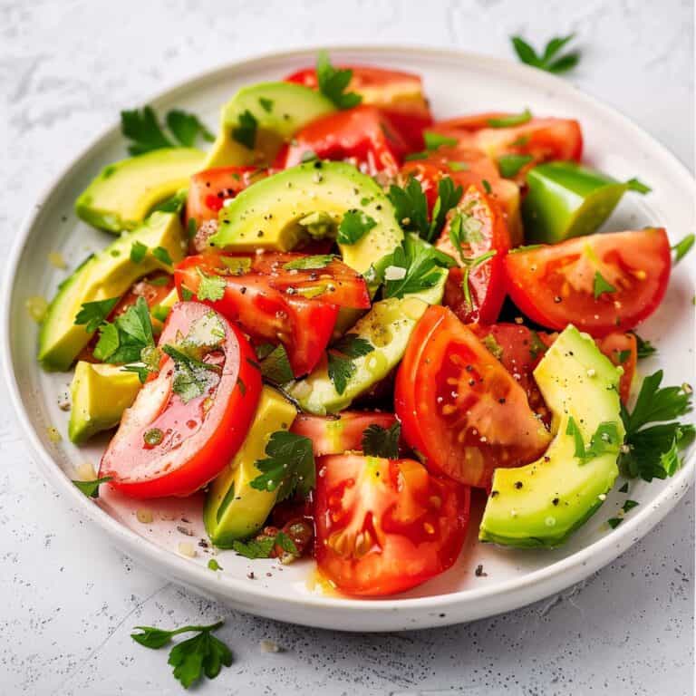 omato avocado salad served on a white plate, showcasing vibrant colors.