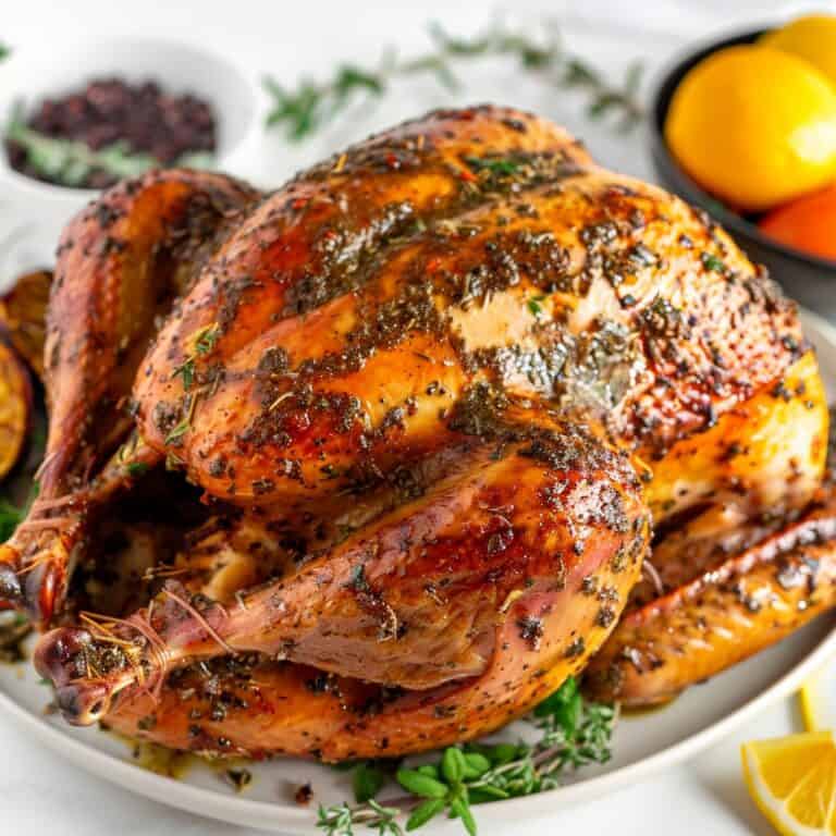 Golden roasted turkey on a white platter, perfectly seasoned with a dry brine for enhanced flavor and juiciness.