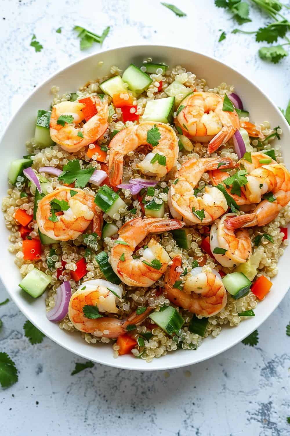 A vibrant shrimp and quinoa bowl featuring juicy shrimp, fresh vegetables, and a zesty cilantro lime dressing for a healthy, flavorful meal.