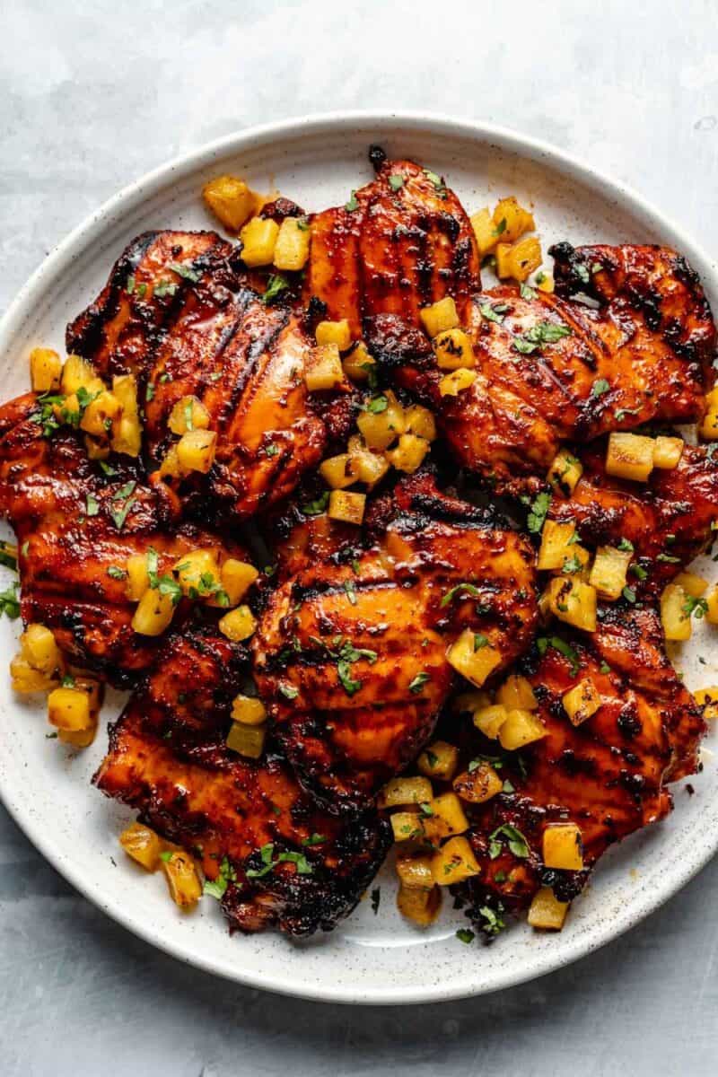 An image featuring chicken thighs marinated in Easy Al Pastor Marinade, showing the vibrant red color and rich coating of spices and pineapple juice. The marinated chicken is ready for cooking, promising a deliciously flavorful result, perfect for any Al Pastor dish.