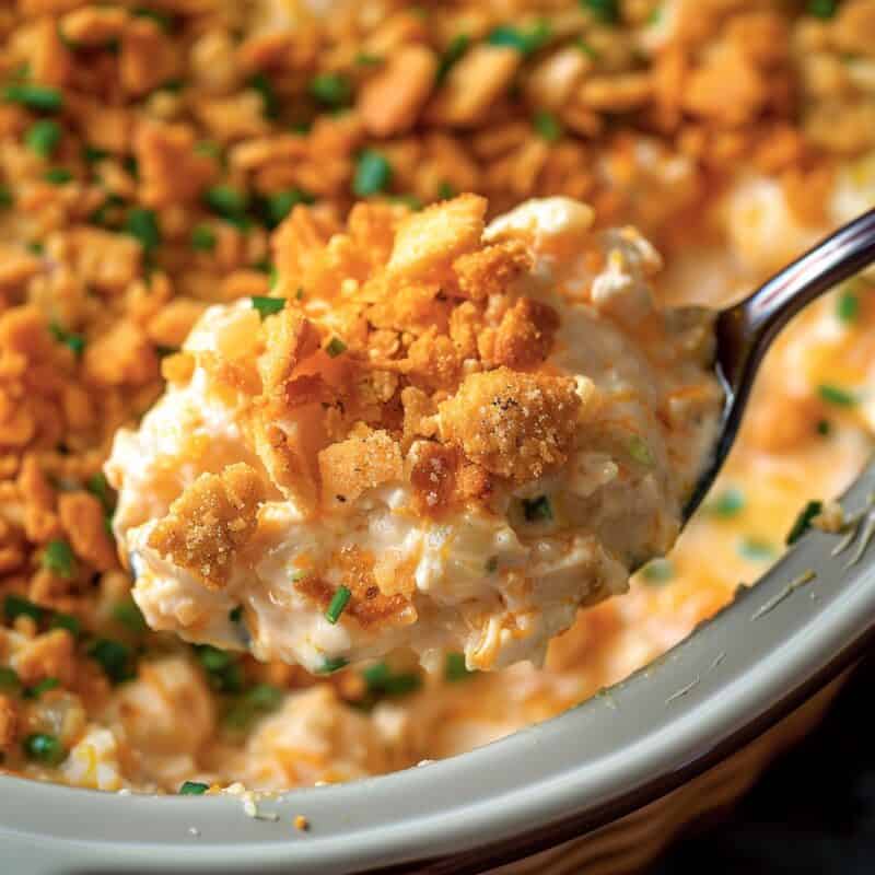 A golden, bubbling Million Dollar Chicken in a crockpot, featuring a creamy, savory filling of tender chicken mixed with cream cheese, cottage cheese, and sour cream, seasoned with garlic and onion powder, all topped with a crispy, buttery layer of crushed Ritz crackers.