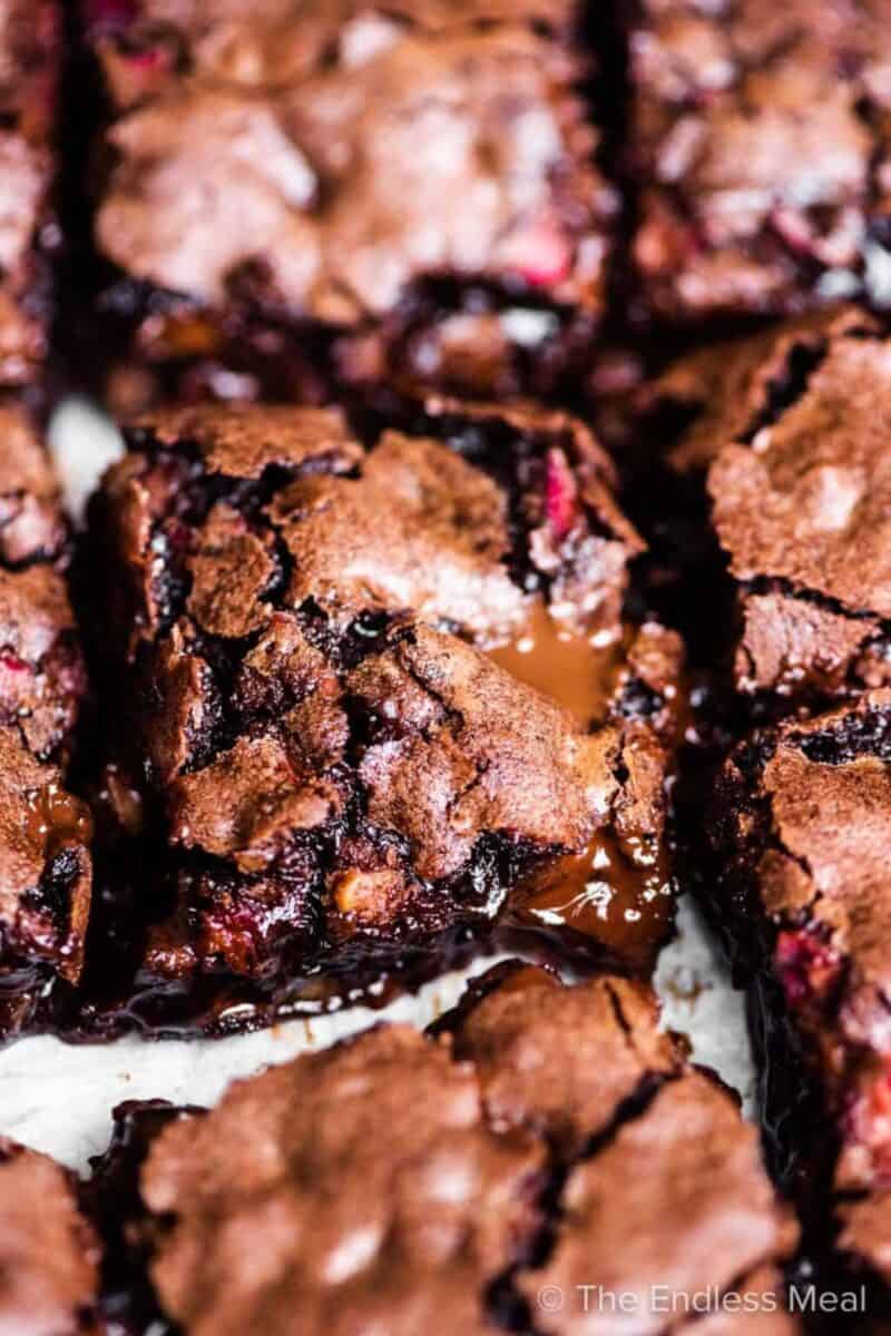 Gooey dark chocolate rhubarb brownies in a baking dish, with a focus on the fudgy center.
