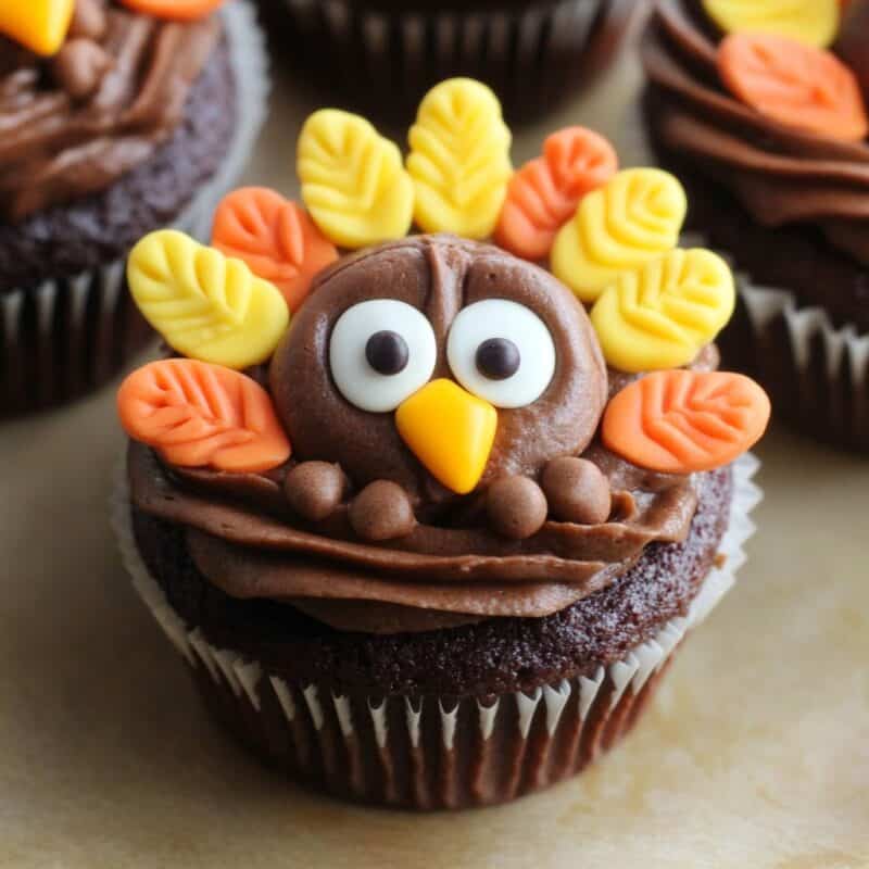 Chocolate cupcakes decorated as cute turkeys with colorful icing feathers and expressive eyes.